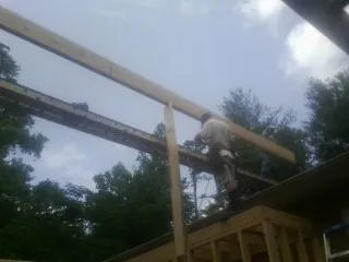 Carpenter setting a ridge beam over a new addition frame — Ice Dam Removal by Roofing Brothers in Elm Grove