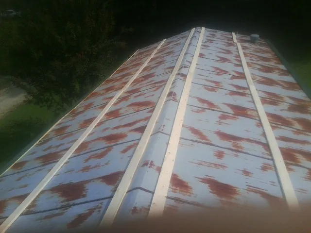 Rusted metal roof panels with new wood purlins before replacement — Storm Damage Roof Repair in Elm Grove by Roofing Brothers