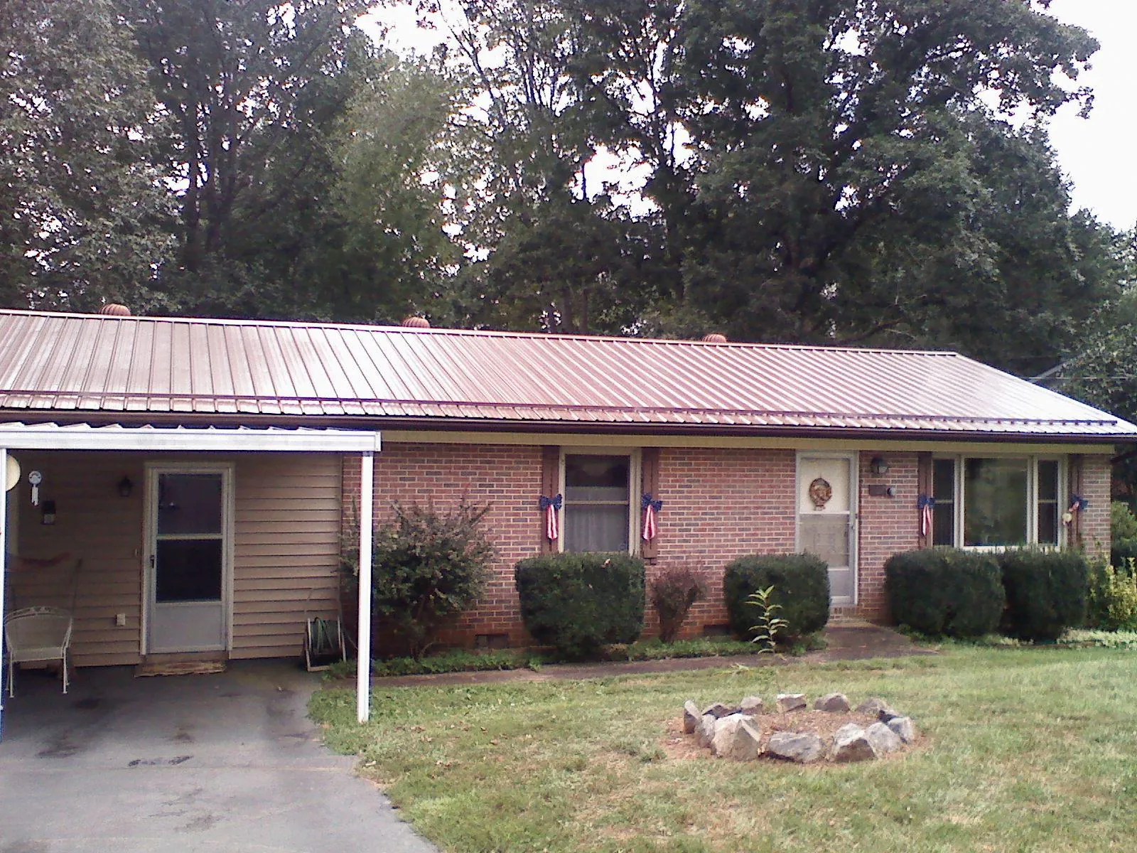 Bronze metal roof and carport on a brick ranch home — Roof Repair work by our crew in Elm Grove