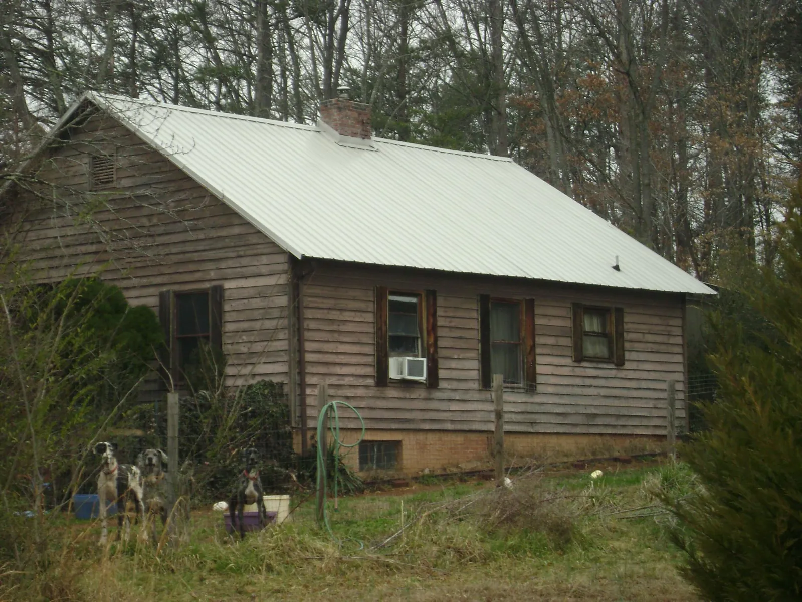 White metal roof on an old wood sided farmhouse, from a Metal Roof Installation job in Elm Grove